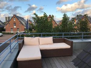 a couch on a balcony with a view of a city at Lichtmeer in Westerland (Sylt)