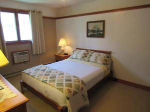 um pequeno quarto com uma cama e uma janela em Carlson's Lodge em Twin Mountain