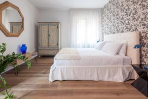 - une chambre avec un grand lit blanc et un miroir dans l'établissement Laguna Boutique Apartments, à Mestre