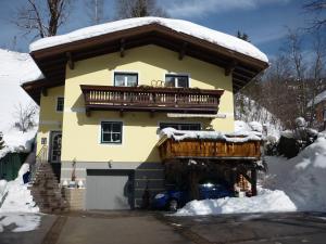 ein großes gelbes Haus mit Balkon im Schnee in der Unterkunft Haus Fritzenwallner Appartement 2 in Wagrain