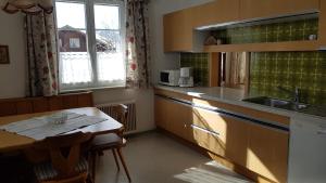 eine Küche mit einem Tisch, einem Waschbecken und einer Arbeitsplatte in der Unterkunft Ferienwohnung Szöky in Bad Mitterndorf