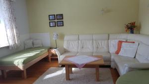 salon z białą kanapą i stołem w obiekcie Ferienwohnung Szöky w mieście Bad Mitterndorf