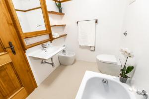 Un baño blanco con lavabo e inodoro. en Dolomiti Sweet Lodge, en Cortina dʼAmpezzo 15 fotos más