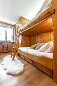 ein Schlafzimmer mit einem Etagenbett mit einer Leiter in der Unterkunft Dolomiti Sweet Lodge in Cortina d'Ampezzo