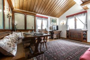 ein Wohnzimmer mit einem Tisch und einem Sofa in der Unterkunft Dolomiti Sweet Lodge in Cortina d'Ampezzo