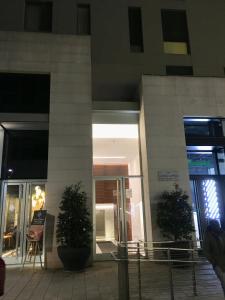 a building with a door and two plants in front of it at Corso Como New Building Apartment in Milan