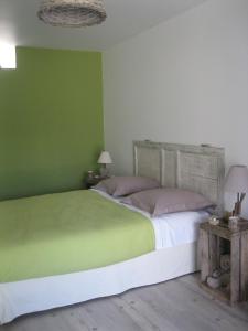 紹維尼的住宿－LA MAISON D'HENRI，绿色卧室,配有床和两张桌子