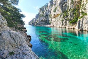 a body of water next to a rocky cliff at Le Poilu 40 m2 in La Ciotat