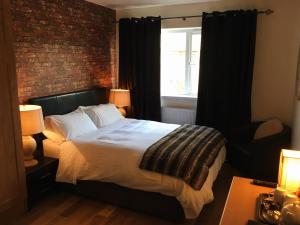 a bedroom with a bed and a brick wall at Abbeyvilla Guesthouse Room Only in Adare