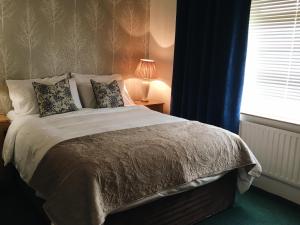 a bedroom with a large bed with a window at Abbeyvilla Guesthouse Room Only in Adare