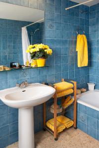 uma casa de banho em azulejos azuis com um lavatório e uma banheira em Hotel Bulevard em Platja d'Aro
