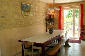 a dining room table with a vase on top of it at Gite de la Cour Vautier in Mandeville-en-Bessin