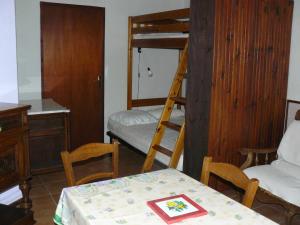 Zimmer mit einem Tisch und einem Etagenbett in der Unterkunft Le Claux des Hespérides in Allemagne-en-Provence