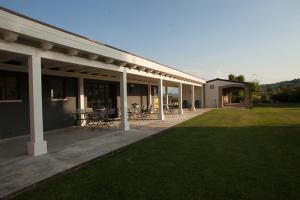 - un bâtiment doté d'une terrasse avec des chaises et des tables dans l'établissement La Chiave Bianca, à Miglianico