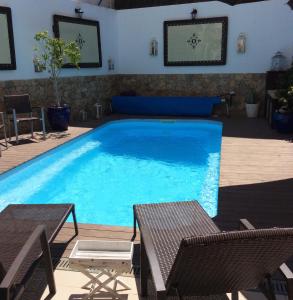 a large swimming pool with two chairs and a table at Opus One Luxury Guest House & Wine in Faro