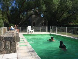 a group of people swimming in a swimming pool at Reina de las Cortaderas in Merlo