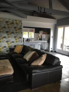 a black leather couch in a living room at B&B Les Hauts d'Ornans in Ornans