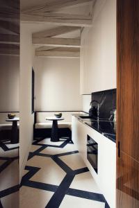 uma cozinha com paredes brancas e pisos em preto e branco em Palazzo Cristo em Veneza