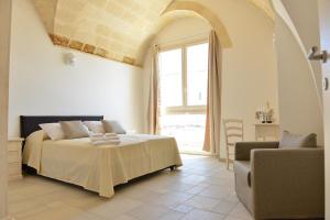 Un dormitorio con una cama y una ventana grande. en Tobacco Suite, en Mesagne