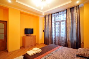 una camera da letto con pareti gialle, TV e letto di Квартира на Золотых воротах, Центр a Kiev
