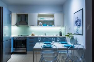 a kitchen with blue cabinets and a table with chairs at Chanion One Suites by Good Life in Heraklio