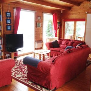 a living room with red couches and a tv at Tudor Lodge in Liskeard