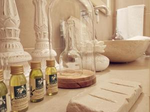 um balcão de casa de banho com garrafas de sabão e um lavatório em Le Nicchie Guest House em Lucera
