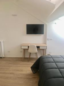 a bedroom with a desk and a bed and a tv at CORSO VENEZIA APARTMENT in Milan