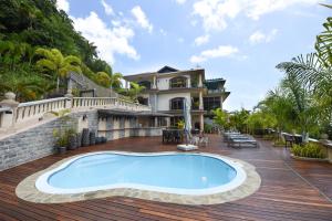 a house with a swimming pool on a wooden deck at Ocean Terrace in Anse Royale