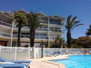 a resort with a swimming pool and palm trees at Location d Armelle - Moliets in Moliets-et-Maa