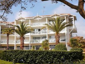ein großes weißes Gebäude mit Palmen davor in der Unterkunft Location d Armelle - Moliets in Moliets-et-Maa