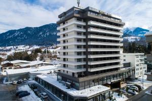 a tall white building with snow on the ground at Eden Hotel und Restaurant in Ilanz