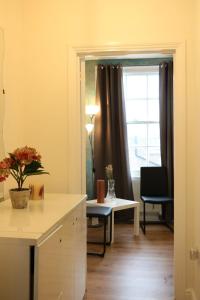 een woonkamer met een tafel en een raam bij Victoria style flat near Victoria station in Londen