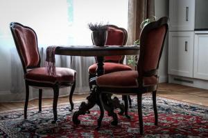 a dining room table with two chairs and a table with a plant at Posti Apartment in Haapsalu +12 photos