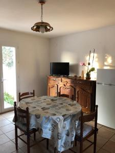 a dining room with a table and a refrigerator at Appartement de l'olivier in Saintes-Maries-de-la-Mer