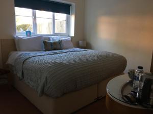 a bedroom with a large bed with a window at The Queen Hotel in Olney +24 photos