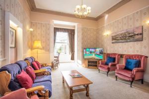 a living room with couches and a tv at Lindum Lodge in Torquay