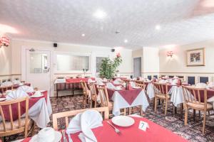 a dining room with red tables and chairs at Lindum Lodge in Torquay