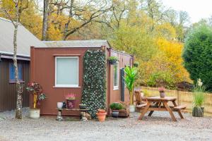 ein winziges Haus mit einem Picknicktisch und Pflanzen in der Unterkunft Room with a view in Spean Bridge