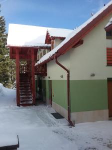 un bâtiment avec de la neige sur le toit et un escalier dans l'établissement Hudinja 111, à Vitanje