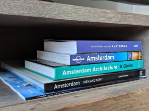 una pila di libri seduti su uno scaffale di Amsterdam City Oasis ad Amsterdam