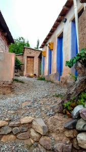brukowana ulica z budynkiem z niebieskimi drzwiami w obiekcie Casa Colores w mieście Tilcara