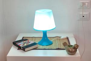 niebieska lampa siedząca na stole obok książki w obiekcie Appuntamento a Ponte Vecchio we Florencji