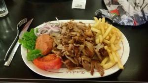 une assiette de nourriture avec un sandwich et des frites dans l'établissement Jonnys Ferienwohnung, à Peraia