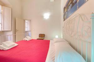 una camera da letto con un grande letto con una coperta rossa di Appuntamento a Ponte Vecchio a Firenze
