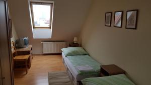 een kamer met 2 bedden, een bureau en een televisie bij Apartmány Račianska in Bratislava