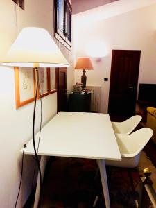 une table et des chaises blanches dans une pièce avec une lampe dans l'établissement B&B Mo Va Là, à Budrio
