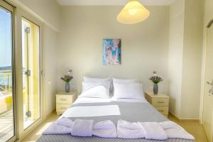 a bedroom with a large bed with purple pillows at Villa Sofia Amazing Views in Agios Georgios Pagon