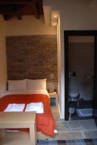 a bedroom with a bed with an orange blanket at Thalia Rooms in Kalabaka