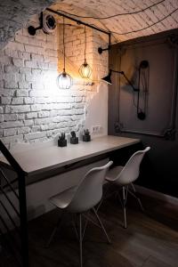 a room with a table, chairs and a lamp at LvivSon Apartments in Lviv